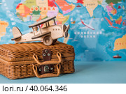 Туризм. Модель старинного самолета и чемодан на фоне карты мира. Концепция путешествий, приключений и открытий. (2023 год). Стоковое фото, фотограф Photojuli / Фотобанк Лори