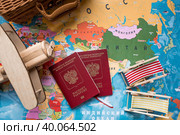 Туризм. Модель старинного самолета, чемодан и российский паспорт на фоне карты мира. Концепция путешествий, приключений и открытий. (2023 год). Стоковое фото, фотограф Photojuli / Фотобанк Лори