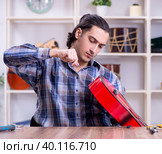 Young handsome repairman repairing guitar. Стоковое фото, фотограф Elnur / Фотобанк Лори