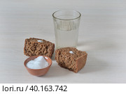 Преломленный темный хлеб с солью и стакан с водой. Стоковое фото, фотограф Владимир Литвинов / Фотобанк Лори