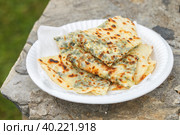 Gozleme. A traditional dish of Turkish cuisine in the form of flatbread stuffed with greens and cheese, wrapped inside. Baked in a pan called a saj. Selective focus (2019 год). Стоковое фото, фотограф Виктория Панченко / Фотобанк Лори