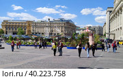 Люди гуляют по Манежной площади в центре Москвы теплым солнечным днем. Жители и гости столицы посещают московские достопримечательности. Вид на отель "Националь". Рыбная неделя. Москва, Россия, 30 мая 2022. People walk on Manezhnaya Square in the center of Moscow on a warm sunny day. Residents and guests of the capital visit Moscow attractions. View of the National Hotel. Fish week. Moscow, Russia, May 30, 2022. Редакционное видео, видеограф Ирина / Фотобанк Лори
