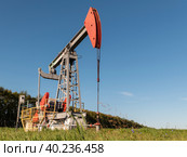 Operating oil and gas well in oil field, profiled against the blue sky. Стоковое фото, фотограф Фотограф / Фотобанк Лори