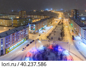 Норильск, Красноярский край, Сибирь, Россия. Вид сверху на Красноярскую улицу в городе Норильск. Снегопад холодным зимним вечером в Арктике. Красочное уличное освещение большого северного города. Стоковое фото, фотограф Андрей Степанов / Фотобанк Лори