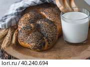 Классическая пшеничная коса или плетёнка с маком. Вкусный хлеб крупным планом. Свежеиспеченный хлеб на закваске с золотистой корочкой на деревянной доске. Контекст пекарни с вкусным хлебом. Кондитерские изделия. Стоковое фото, фотограф Photojuli / Фотобанк Лори