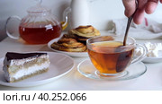 Hand stirs a teaspoon of sugar in a cup. Breakfast with cake. Стоковое видео, видеограф Ирина Толокновская / Фотобанк Лори