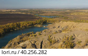 Drone Flying above brown texture hills away from lake with yellow autumn trees - Zoom out panorama. Стоковое видео, видеограф Кирилл Трифонов / Фотобанк Лори
