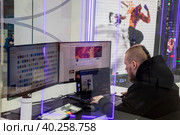 Диджитал-художник Артём Ткач создает графические изображения за компьютером на ярмарке современного искусства Art Russia в городе Москве, Россия (2023 год). Редакционное фото, фотограф Николай Винокуров / Фотобанк Лори