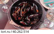 Delicious steamed mussels in shells in two-handled metal serving pan with slice of lemon. Popular seafood appetizer. Стоковое видео, видеограф Яков Филимонов / Фотобанк Лори