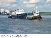 RUSSIA / ROSTOV-ON-DON - 08/01/2020: Small boat "Antey" towed the damaged ship on the river in the dock for repairs. Редакционное фото, фотограф Валерий Елистратов / Фотобанк Лори