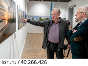 Участник фотовыставки Евгений Кулешов у своих работ. Редакционное фото, фотограф Андрей Дегтярёв / Фотобанк Лори