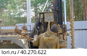 Team of workers with drilling rig on car are drilling artesian well for water in ground. Insertion of metal casing pipe into ground, installation of individual drinking supply, June 28, 2022, Russia, Palaces. Редакционное видео, видеограф Ольга Симонова / Фотобанк Лори