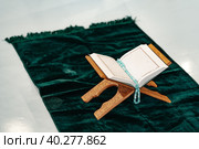 Holy Quran with prayer rosary beads on wooden stand. Стоковое фото, фотограф Сергей Толмачёв / Фотобанк Лори