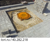 Укладка тротуарной плитки вокруг канализационного люка. Стоковое фото, фотограф Вячеслав Палес / Фотобанк Лори