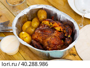 Whole chicken baked with potatoes in tinfoil deep bowl. Стоковое фото, фотограф Яков Филимонов / Фотобанк Лори