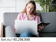 Young caucasian woman using computer, looks at device screen, distance work. Стоковое фото, фотограф Оксана Гильман / Фотобанк Лори