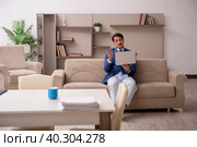 Young male employee working from home during pandemic. Стоковое фото, фотограф Elnur / Фотобанк Лори