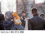 Russia, the City of Vidnoye, April 15, 2023. Easter service. The priest sprinkles people and Easter treats with holy water at the entrance to the temple. People go to sanctify eggs and cakes. Редакционное фото, фотограф Photojuli / Фотобанк Лори