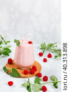 Milkshake with raspberries in a glass glass with melissa leaves in the design with copy space. Стоковое фото, фотограф Неведицына Елена / Фотобанк Лори