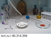 Beta-alanine in powder on a laboratory table with a signature of the structural chemical formula of the molecule. B-alanine is a non-essential amino acid. It is often taken as a sports supplement. Стоковое фото, фотограф Mikhail Abramov / Фотобанк Лори
