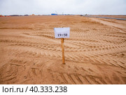 Flat sand subgrade, sign and truck trails. Blue sky on horizon. Стоковое фото, фотограф Alexey Rezvykh / Фотобанк Лори
