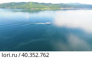 A ship with tourists goes along Lake Baikal. View of the village of Listvyanka. Стоковое видео, видеограф Виктория Тельминова / Фотобанк Лори