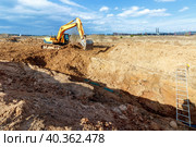 Excavator dig the trenches at a construction site. Trench for laying external sewer pipes. Sewage drainage system for a multi-story building. Digging the pit foundation. Стоковое фото, фотограф Дмитрий Головач / Фотобанк Лори