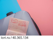 A flat with a gray tourist suitcase, a smartphone, and glasses on a pink-blue background. Стоковое фото, фотограф Ярославский Максим / Фотобанк Лори