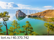 Picturesque landscape of Baikal Lake in June sunny day. View from the shore of Olkhon Island to Shamanka Rock - a natural landmark of the lake. Summer travel and outdoor recreation. Natural background. Стоковое фото, фотограф Виктория Катьянова / Фотобанк Лори