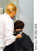 real female haircut in a beauty salon. female hairdresser and client. female business. shaving the back of the head. vertical frame. Стоковое фото, фотограф Антон Вахрушев / Фотобанк Лори