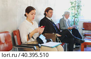 Unemployed young woman sits and waits for invitation to interview. Bored woman candidate with smartphone waiting for invitation to recruiter office. Стоковое видео, видеограф Яков Филимонов / Фотобанк Лори