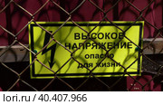 Табличка "Высокое напряжение. Опасно для жизни!» жёлтого цвета за сетчатым забором. Стоковое видео, видеограф Евгений Ковальский / Фотобанк Лори