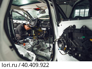 Car service worker installing noise insulation soundproofing in the car. Стоковое фото, фотограф Сергей Толмачёв / Фотобанк Лори