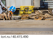 bulk of old manhole wellsold manholes of wells piled in a heap, next to temporary road signs and emergency barriers. Стоковое фото, фотограф Дмитрий Коростылев / Фотобанк Лори