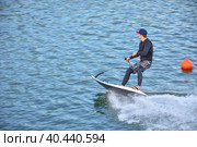 Motosurf Competitor taking corner at speed making a lot of spray. Jet surfing on a water, man riding on jet surfboard. Surfer in motion, summer sport. Стоковое фото, фотограф Олег Спиридонов / Фотобанк Лори