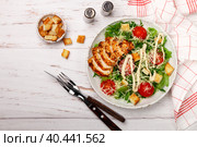 Healthy Grilled Chicken Caesar Salad with iceberg or lettuce, Cheese Parmesan, cherry tomatoes, bread Croutons and gourmet sauce. Selective focus, top view and copy space. Стоковое фото, фотограф Виктория Панченко / Фотобанк Лори