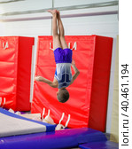 A young athlete performs a jump somersault in the gym. (2019 год). Редакционное фото, фотограф Юрий Поздников / Фотобанк Лори