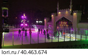 People skate in the evening on a lighted ice rink. A blizzard is raging and snow is falling. Zelenograd, Russia 28.01.2022. Редакционное видео, видеограф Юрий Поздников / Фотобанк Лори