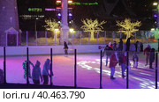 People skate in the evening on a lighted ice rink. A blizzard is raging and snow is falling. Zelenograd, Russia 28.01.2022. Редакционное видео, видеограф Юрий Поздников / Фотобанк Лори