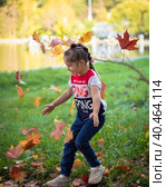 The girl throws colorful maple leaves for a walk in the park. Russia Moscow September 24, 2020. Редакционное фото, фотограф Юрий Поздников / Фотобанк Лори