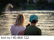 Mom with children sits on the pier by the pond at sunset. Russia Moscow September 24, 2020. Стоковое фото, фотограф Юрий Поздников / Фотобанк Лори