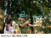 Brother and sister play and laugh in the park in summer. Russia Moscow September 24, 2020. Редакционное фото, фотограф Юрий Поздников / Фотобанк Лори