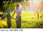 Mom plays and dances with children in the park, laughs and spins with happiness. Russia Moscow September 24, 2020. Редакционное фото, фотограф Юрий Поздников / Фотобанк Лори