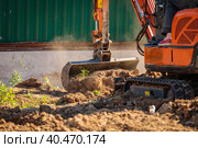 A minitractor rakes the earth with a bucket. Land works. Стоковое фото, фотограф Юрий Поздников / Фотобанк Лори
