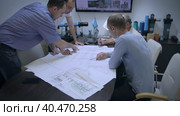 Engineers and managers in a meeting room discuss drawings and problem solving methods. Experts argue and express their opinion. Slow motion. Moscow Russia October 9, 2022. Редакционное видео, видеограф Юрий Поздников / Фотобанк Лори