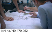 Engineers and managers in the conference room discuss drawings and problem solving methods. They show with their hands where changes are needed. Стоковое видео, видеограф Юрий Поздников / Фотобанк Лори