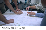 Engineers and managers in the conference room discuss drawings and problem solving methods. They show with their hands where changes are needed. Стоковое видео, видеограф Юрий Поздников / Фотобанк Лори