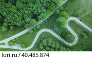 Curvy bike path. Laid between the trees in the park. Drone photography, aerial photography. The camera is tilted vertically down. Стоковое видео, видеограф Vadzim Yakubovich / Фотобанк Лори