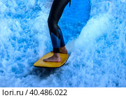 Windsurfer's legs closeup against a background of blue bubbling water and white foam. Стоковое фото, фотограф Iva Noel / Фотобанк Лори