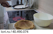 A man pours dough into a flat frying pan. Cooking pancakes at home. Стоковое видео, видеограф Юрий Поздников / Фотобанк Лори